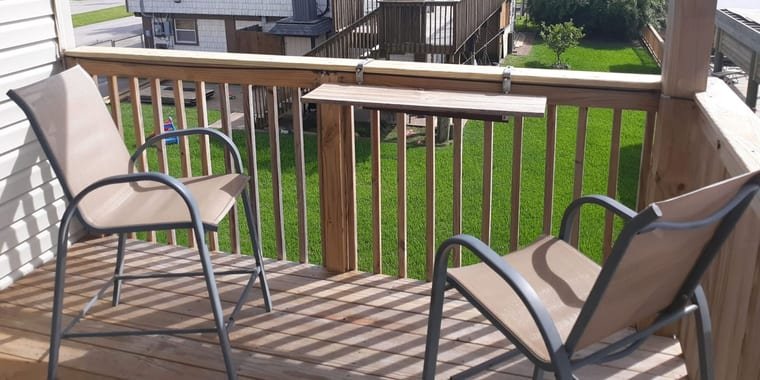 Raised deck with wood railings and a rail-mounted bar table